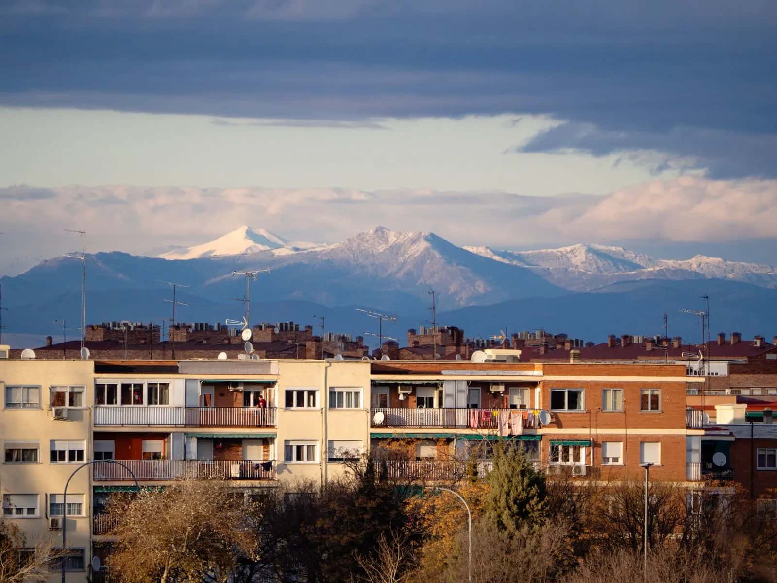 Bloques de viviendas de ladrillo en Madrid con la sierra nevada al fondo