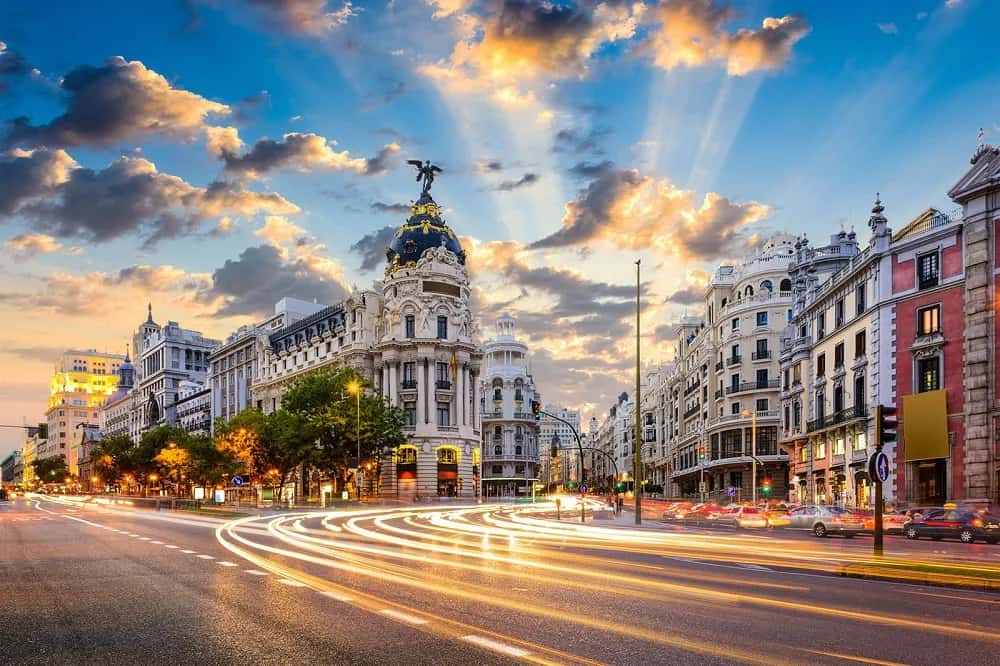 Gran Vía y el edificio Metrópolis de Madrid con estelas de tráfico al atardecer