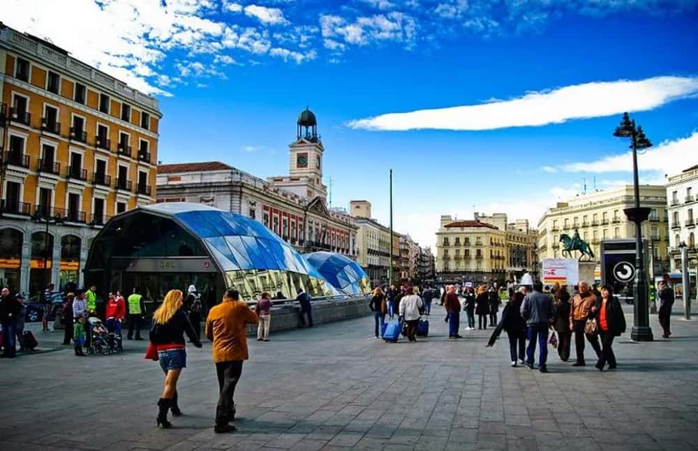 Puerta del Sol de Madrid con gente paseando y la entrada acristalada de Cercanías