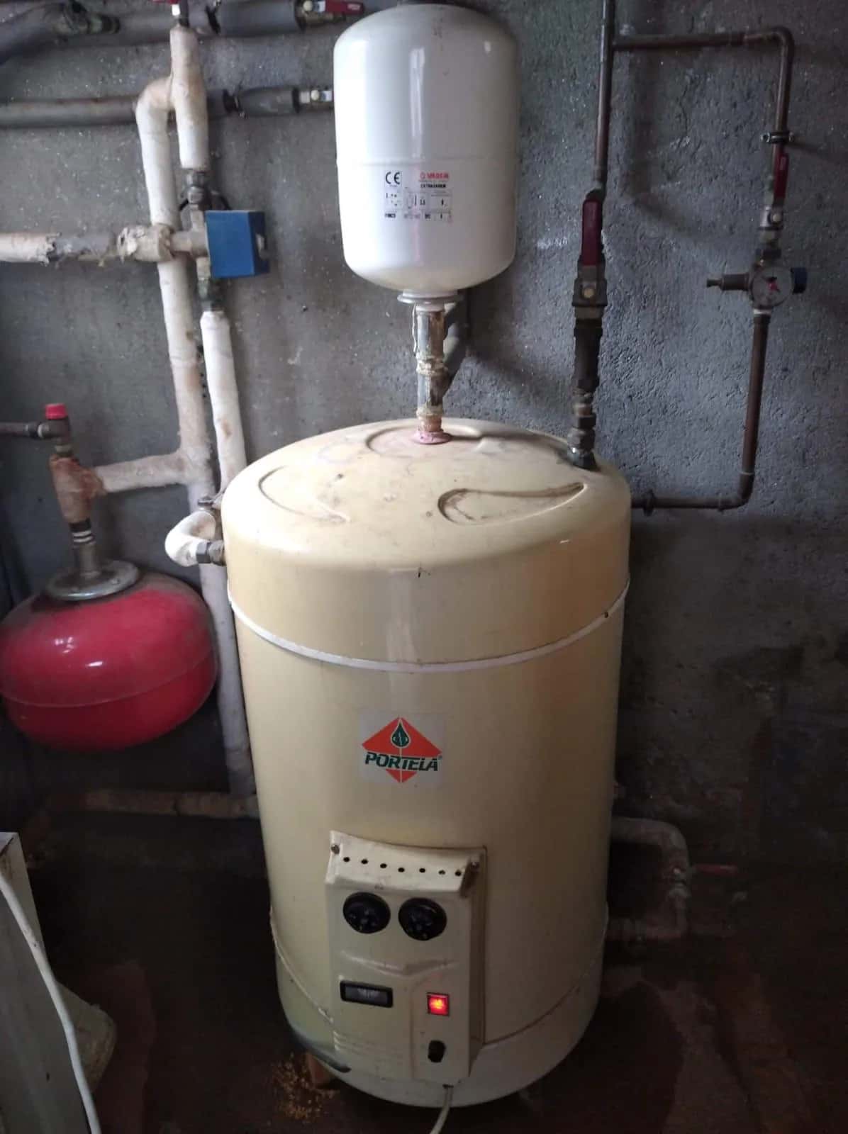 Acumulador eléctrico de agua caliente con vasos de expansión y tuberías en un cuarto técnico