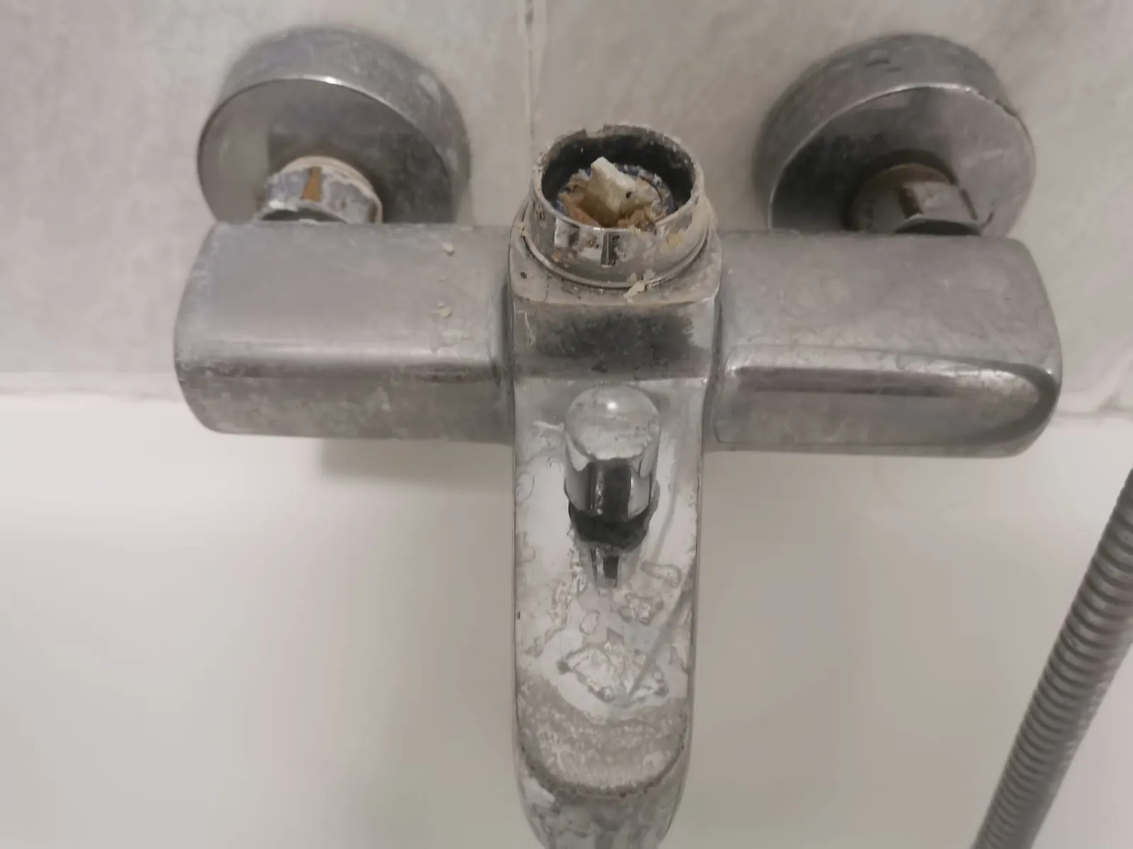 Grifo mezclador de bañera sin maneta con el eje desgastado a la vista