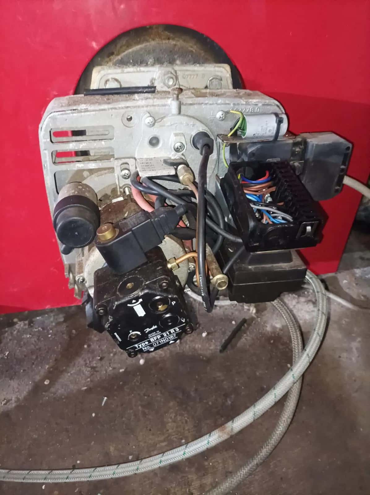Quemador de gasóleo desmontado con cableado y bomba de combustible a la vista