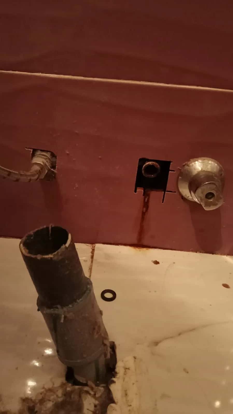 Tubo de desagüe antiguo corroído retirado de la pared de un lavabo